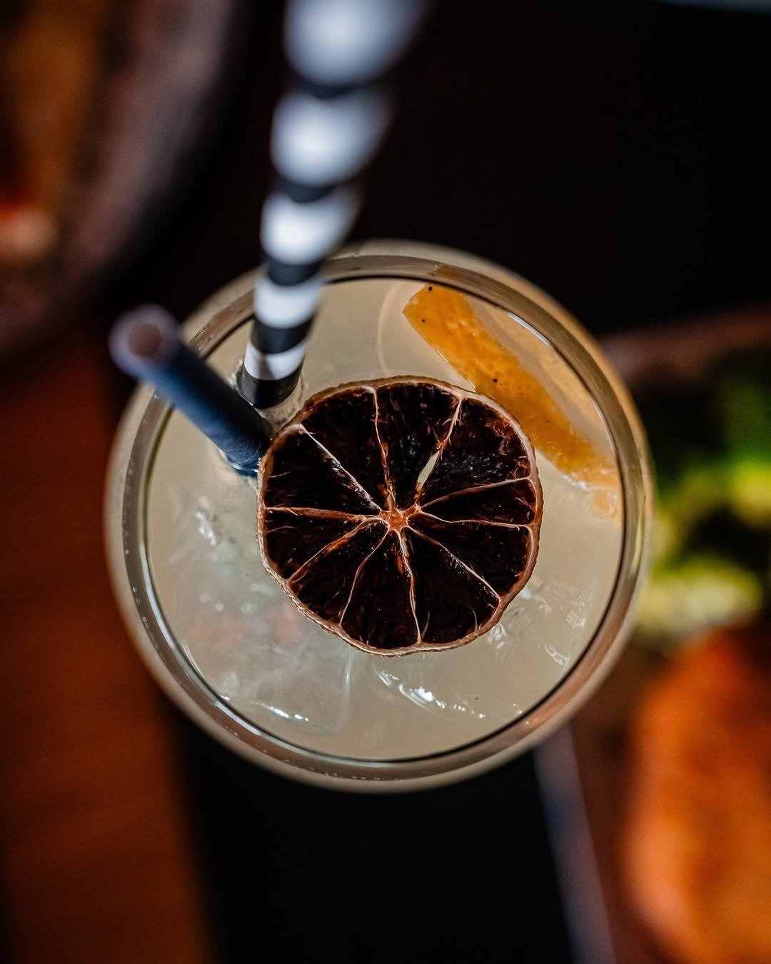 Cocktail com rodela de laranja desidratada, visto de cima